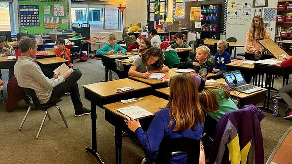 Superintendent Fowler reads to 4th grade students who are seated at theirs desks.