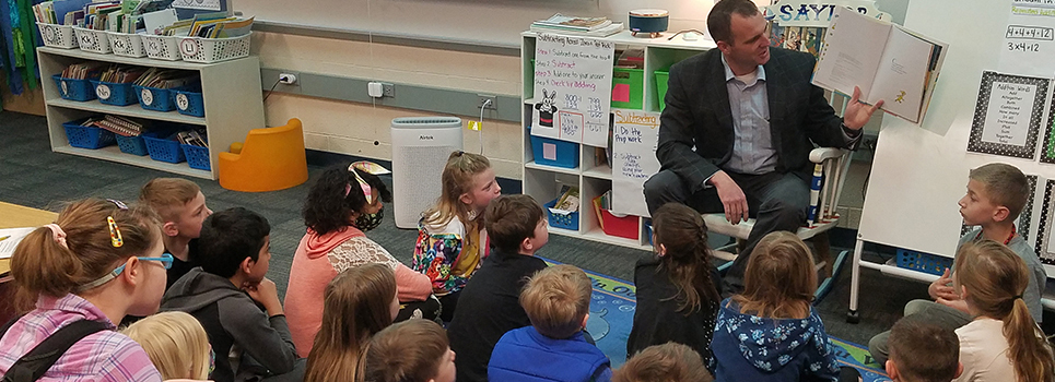 Representative Thomas Albert reads to elementary school students during class.