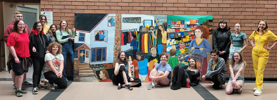 LHS art students pose in front of the mural they created for Flat River Outreach Ministries.