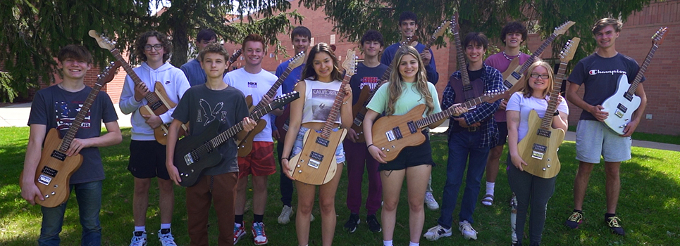 Students show off the guitars they crafted by hand over the course of the school year.